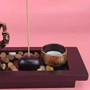 Ganesha incense burner set with wooden tray, candle holder and decorative stones for home.