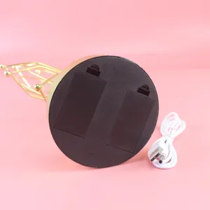 Bottom view of kinetic art perpetual motion desk toy base with dual battery boxes and USB cable.