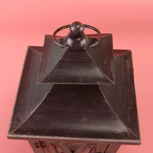 Primo piano dettagliato della parte superiore della lanterna in legno con finitura nera.