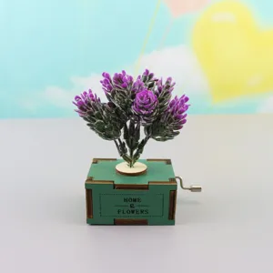 Detailed close-up view of the green wooden hand-crank music box with purple lavender flowers.