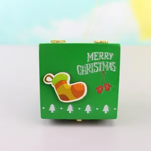 Wooden Christmas hand crank music box, green holiday gift with cute festive patterns for kids.