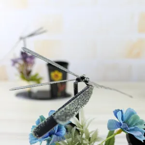 Rotating dragonfly iron pen holder detail view showing metal craft design and wing texture.