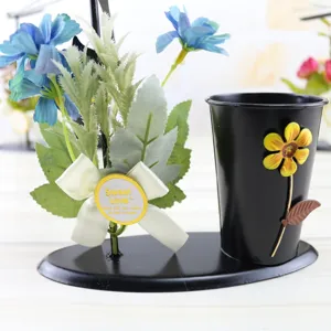 Detail view of the creative iron pen holder featuring blue artificial flowers and cute bow.