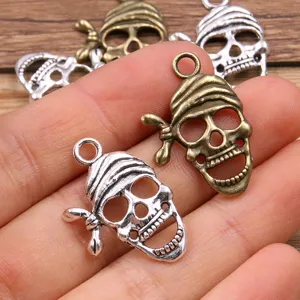 Close-up of metal skull charms with pirate bandana design in silver and antique bronze colors.