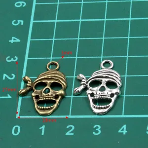 Metal skull charm pendant in antique bronze and silver, 27x18mm DIY jewelry making detail.