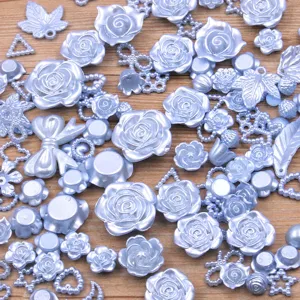 Close up view of mixed light blue resin cabochons, featuring flatback roses and cute bows.
