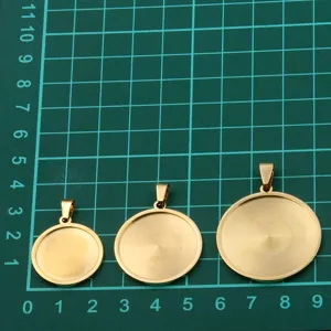 Vue détaillée de plateaux ronds en acier inoxydable pour pendentifs, apprêts DIY dorés.