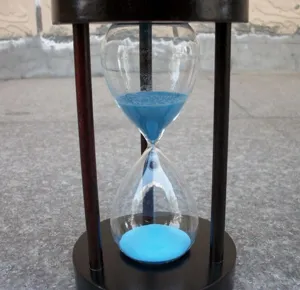 Nahaufnahme einer Holzsanduhr mit blauem Sand, dekoratives Tisch-Zeitmesser-Detail.