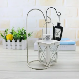 Close-up detail of white iron hanging candle holder and Moroccan wind lamp for home decor.