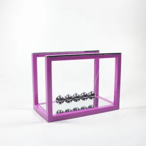 Detail view of the purple frame Newton cradle with mirror base physics science desk toy.