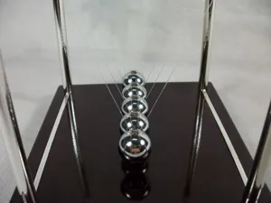 Primer plano de bolas de cuna de Newton con marco cromado y base oscura, decoración de escritorio.