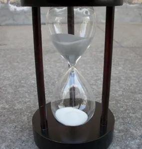 Detailaufnahme der kreativen Sanduhr aus Holz als Tischdekoration mit feinem Sand und.