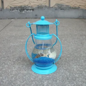 Close-up display of the blue metal jelly candle holder filled with shells and starfish.