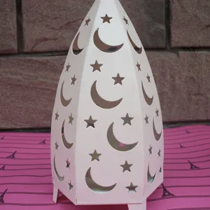 Detailed view of white metal star and moon hollow iron candle holder tabletop decor.
