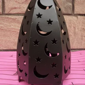 Close-up detail of the black iron hollow star and moon lantern candlestick surface texture.