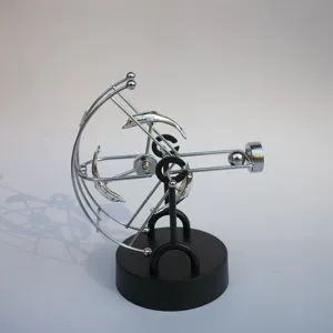 Detailed view of the kinetic art perpetual motion desk toy with swinging dolphin ornaments.