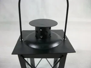 Close-up detail of black iron candle holder top handle and vent design for home decor.