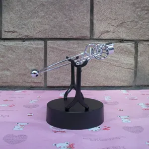 Perpetual motion balance toy detail view, metal physics science desk ornament for office decor.