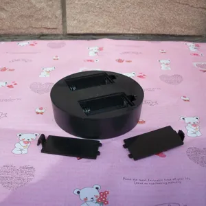 Black plastic perpetual motion base detail showing battery compartment and covers.