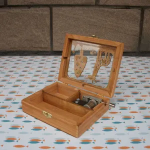 Wooden hand-cranked music box with storage compartments and cutout animal lid design detail.