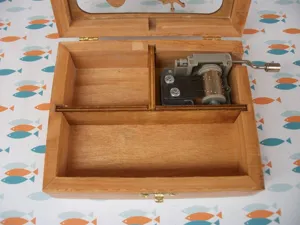 Wooden music box interior detail showcasing the hand crank mechanism and compartment design.