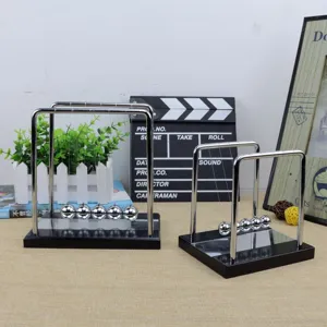 Detailed view of the square wooden base Newton cradle balance balls office desk decor toy.
