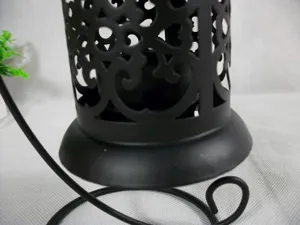 Gros plan détaillé d'un bougeoir en fer creux en métal noir de style vintage avec motifs.