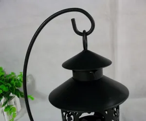 Vue détaillée du bougeoir en fer creux noir avec support suspendu, décor de maison vintage élégant.