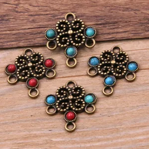 Close-up detail of vintage bronze alloy floral multi-hole jewelry connectors with colorful resin.