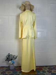 Back view of a solid yellow long-sleeve top and matching skirt set, elegant spring fashion style.