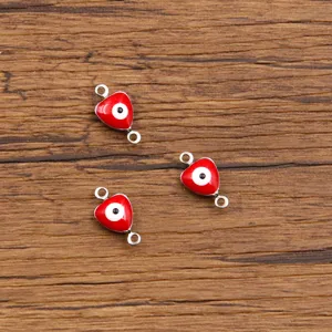 Close up of red heart evil eye connector charms, stainless steel jewelry making findings.