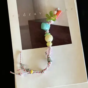Handmade colorful beaded phone charm and strap with cute flower pendants for trendy summer style.