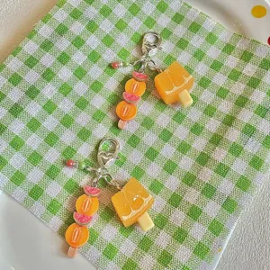 Cute fruit popsicle keychains detail shot, summer fresh style beaded bag charms, cute accessories.