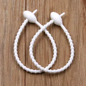 Silicone cable ties detail shot, white reusable elastic strap with oval head for neat organization.