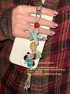 Stylish beaded phone charm with colorful resin flower and tassel design for summer accessorizing.