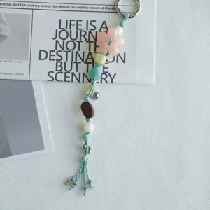 Detailed close-up view of the aesthetic beaded phone charm featuring cute floral and wooden accents.