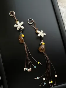 Handcrafted beaded phone charm close-up detail showcasing intricate floral pendants and tassels.