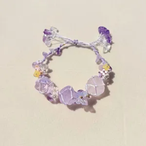 Purple crystal flower woven net bracelet detail, handmade cute gemstone wrist chain accessory.