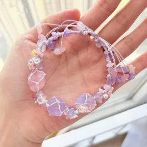 Handcrafted purple crystal woven bracelet detail view featuring delicate stone chips and sweet floral charms.