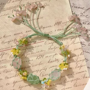 Handgemaakte macrame kristalen armband met rozenkwarts en bloemkralen, unieke boho sieraden.