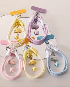 Detailed close-up of cute cloud and star charm phone wrist strap, colorful woven cord design.