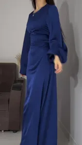 Detailed view of the elegant blue long-sleeve maxi dress with waist-cinching ties.