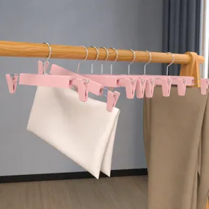 Rosa Kleiderbügel aus Kunststoff mit Metallklammern, starker Halt für die Aufbewahrung.