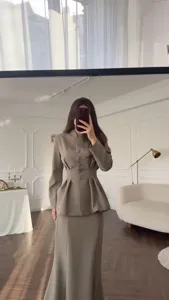 Detailed view of elegant vintage women two-piece suit, featuring cinched waist top and skirt.