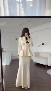 Elegant retro beige two-piece outfit, long sleeve peplum top and mermaid skirt set.