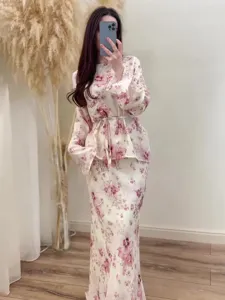 Detail view of floral print two-piece long sleeve top and skirt set in a cozy room.