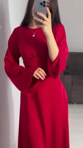 Detail view of the elegant red satin long-sleeve maxi dress showing waist design.