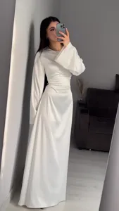 Detail view of elegant long-sleeve white satin maxi dress with waist-cinching design.