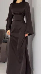 Satin maxi dress detail showing slim fit, long flared sleeves, and elegant waist tie design.