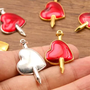 Close-up detail of red enamel heart pierced nail alloy pendant diy jewelry accessory.